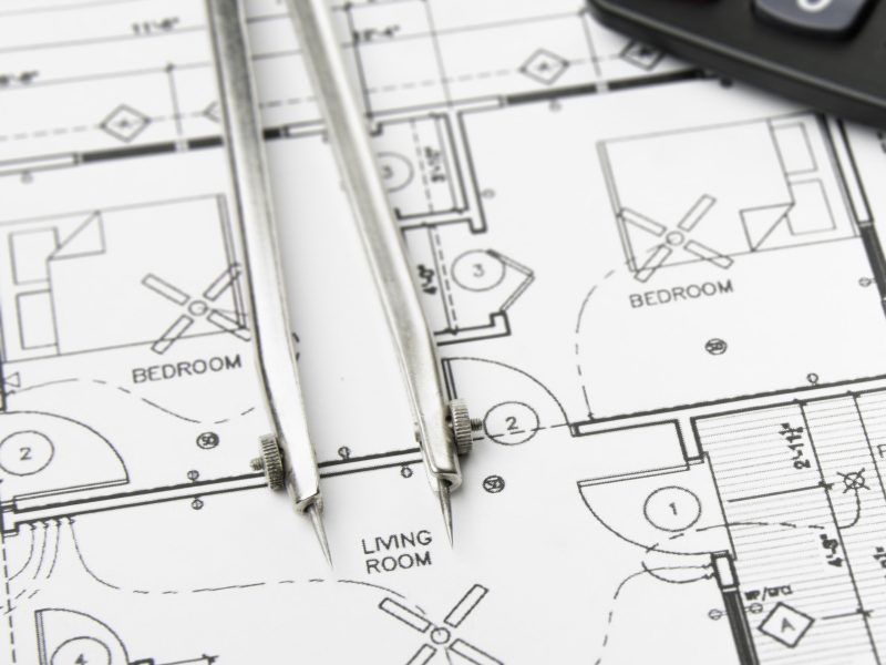 Construction planning drawings on the table and two yellow pencils